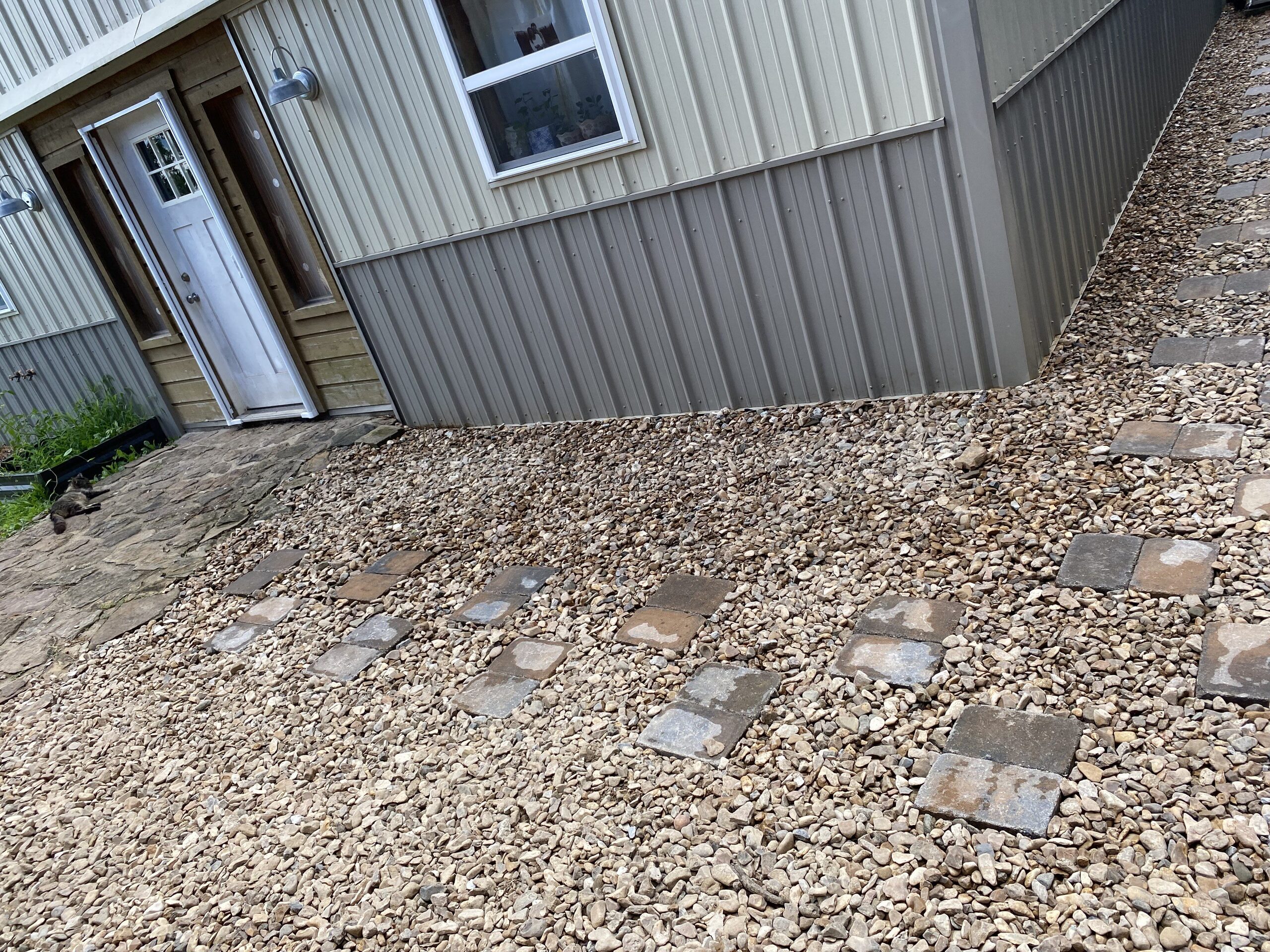 Retaining wall and gravel walkway along the side of a house